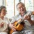 man plays the guitar for woman