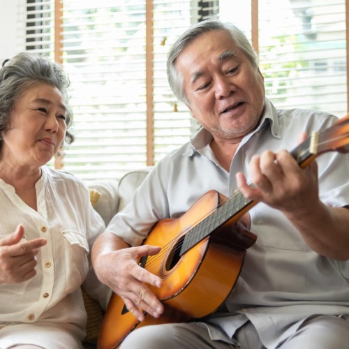 man plays the guitar for woman