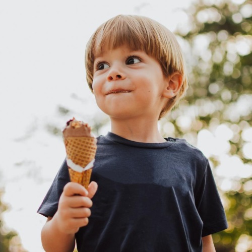 a boy holding an ice cream cone