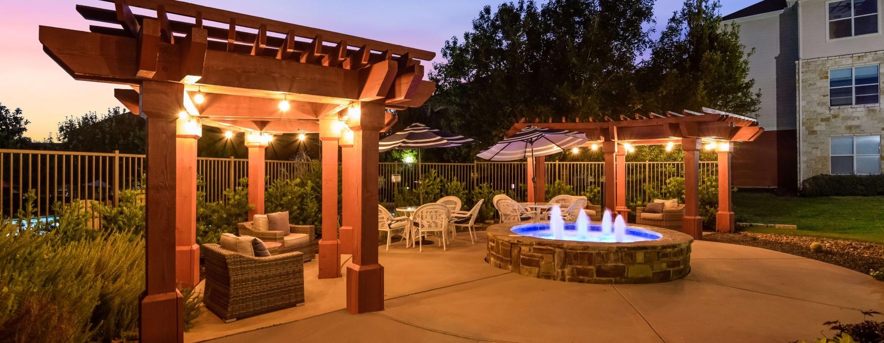 water fountain surrounded by pergola covered seating areas