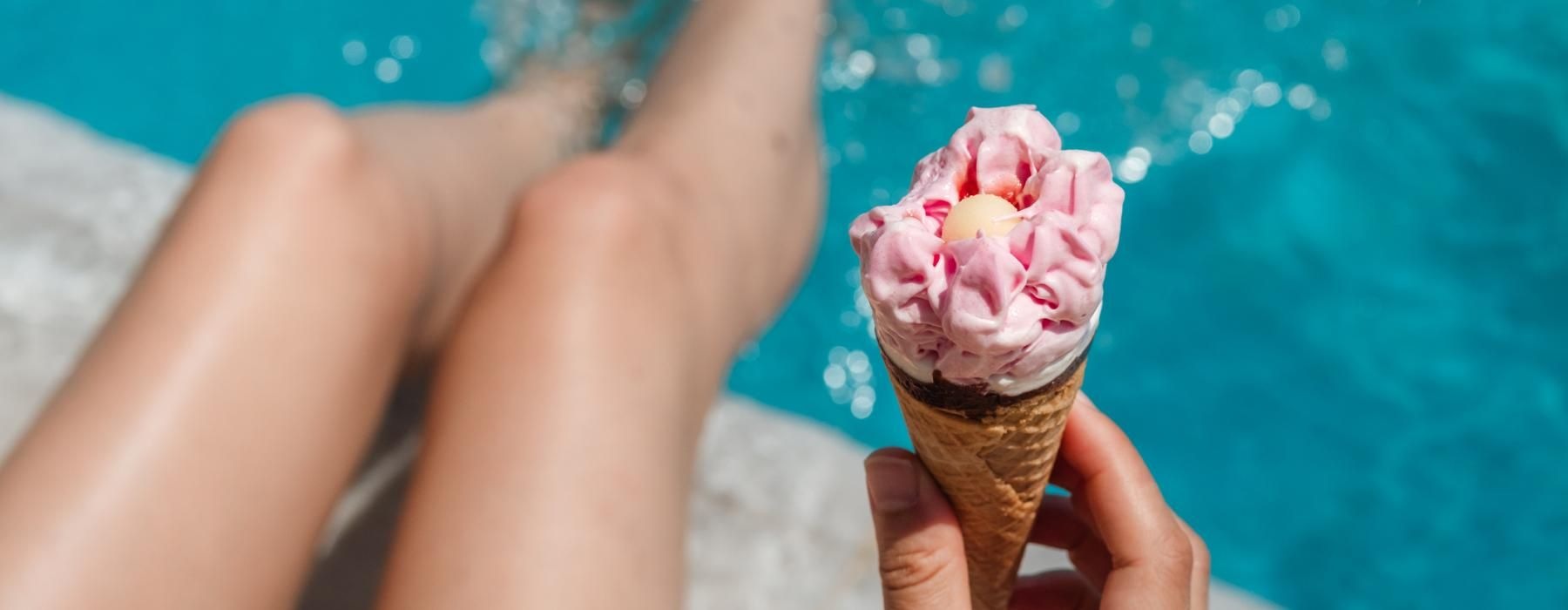 woman holding an ice cream cone near pool